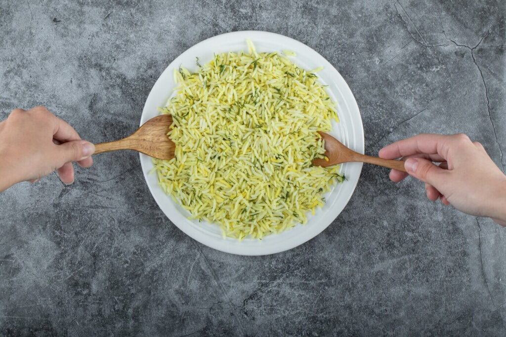 Mulher tirando arroz do prato branco