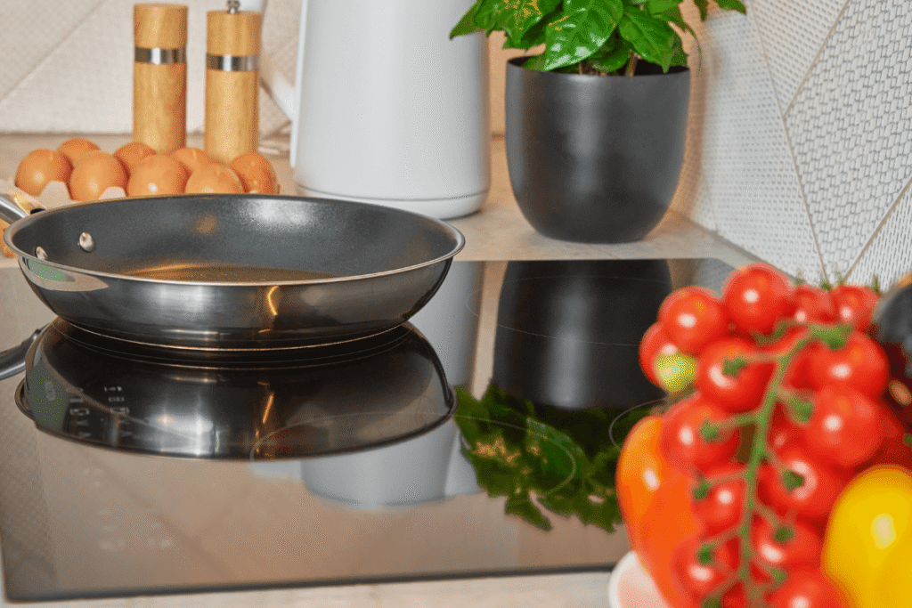 Frigideira antiaderente limpa e seca sobre um fogão moderno, ilustrando o resultado de uma boa manutenção diária para preservar a camada protetora.